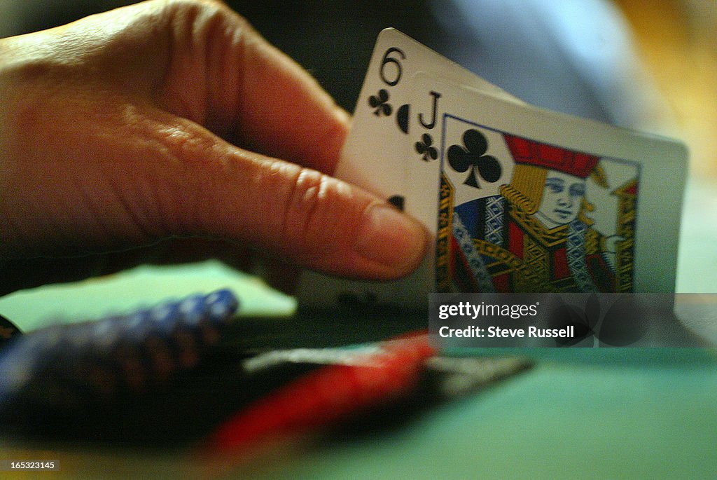 TEXAS HOLD 'EM POKER---03/07/05---A player peeks at their hand, the popularity of Texas Hold 'Em Pok