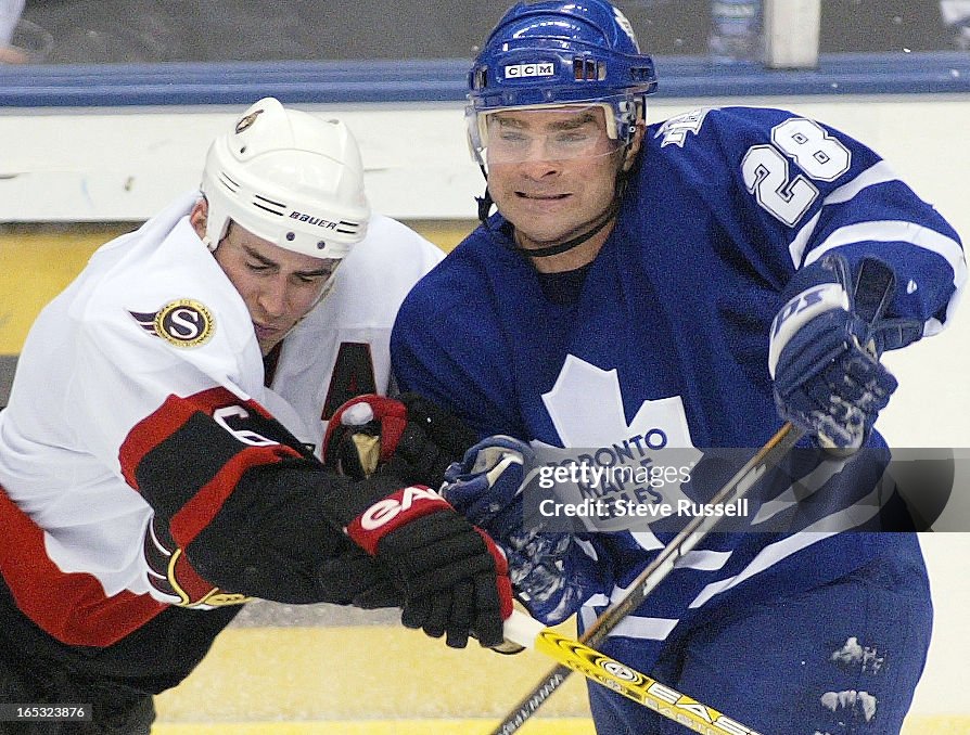 TORONTO MAPLE LEAFS---01/31/04---Tie Domi, wearing a visor, checks Wade Redden as the Toronto Maple 