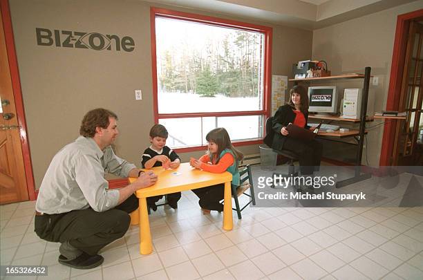 Kevin Jackson with wife Julie King -seated by computer.children Caelin Jackson-King .4 on left and sister Talia Jackson-King .6 on rt playing cards...