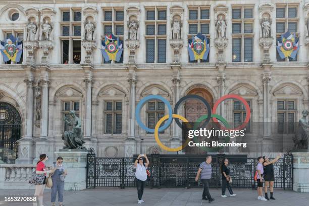 Visitors at the Olympic rings display outside Paris city hall in Paris, France, on Thursday, Sept. 7, 2023. The Summer Olympics will take place next...