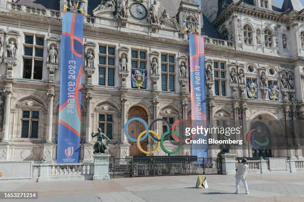 Visitor photographs the Olympic rings display outside Paris city hall in Paris, France, on Thursday, Sept. 7, 2023. The Summer Olympics will take...