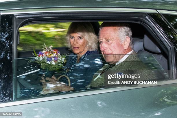 Britain's King Charles III and Britain's Queen Camilla leave after attending church in the village of Crathie, near Balmoral in central Scotland on...