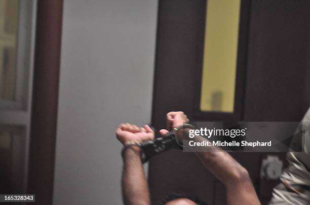 Detainee stretches his arms before a guard escorts him out of Camp 6 on March 30, 2010. All photographs taken by journalists must be reviewed by...