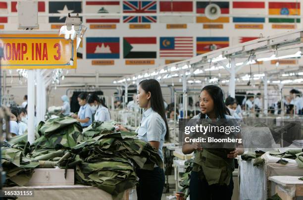 Workers inspect military combat uniforms on the production line in the garment area at a PT Sri Rejeki Isman factory in Sukoharjo, Java, Indonesia,...