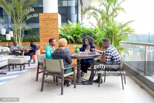 nairobi business team meeting in open-air atrium - nairobi county stock pictures, royalty-free photos & images