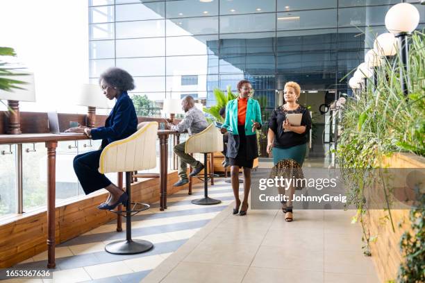 profesionales corporativos que trabajan en edificios de oficinas modernos - áfrica del este fotografías e imágenes de stock