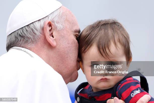 Pope Francis kisses Johnny Oliver Sueeney an American baby from Virginia as he leaves St. Peter's square at the end of his weekly audience on April...