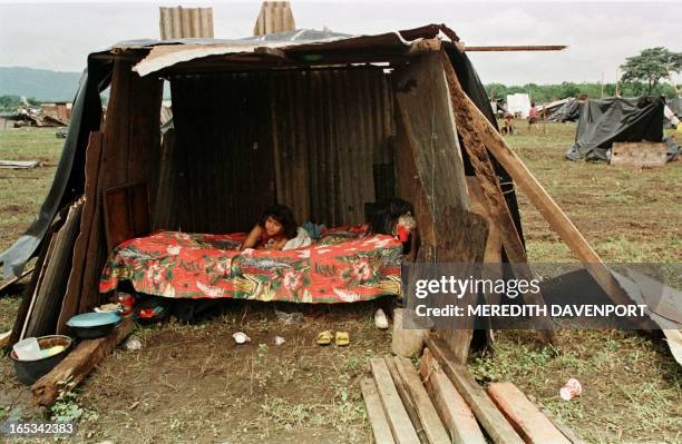 Flood refugee sits in a makeshift temporary home 06 November in Ciudad Sandino on the outskirts of Managua, Nicaragua. Thousands of people who lived...