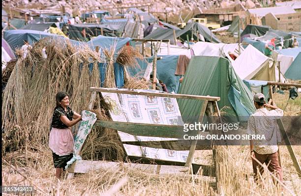 Eduvigues Matamoros, a 67-year-old victim of Hurricane Mitch, builds a hut out of wooden planks and plastic sheeting 11 December on a vacant lot of...