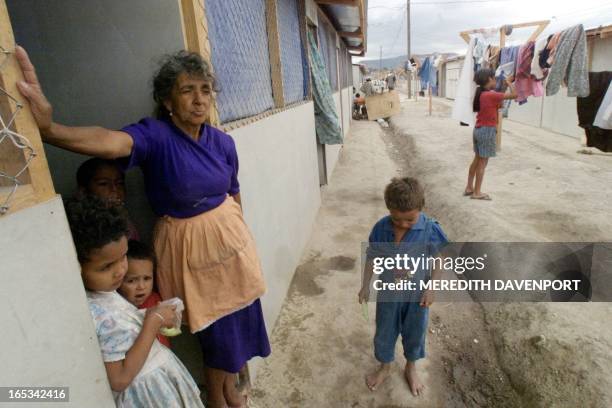 Elena Lagos and her grandchildren, survivors of Hurricane Mitch, stand the doorway of her temporary home 07 March El Trebol refuge in Tegucigalpa....