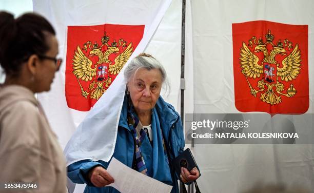 Woman leave the pooling booth on the first day of local elections in Russia, at a polling station in Moscow on September 8 as Muscovites elect the...
