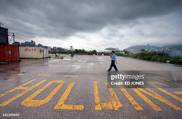 HongKong-property-land-KaiTak,FEATURE by Adrian Addison This photo taken on August 13, 2009 shows a man walking across a section of runway on the...