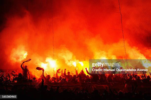 Galatasaray fans light flares during the UEFA Champions League Quarter Final first leg match between Real Madrid and Galatasaray at Estadio Santiago...