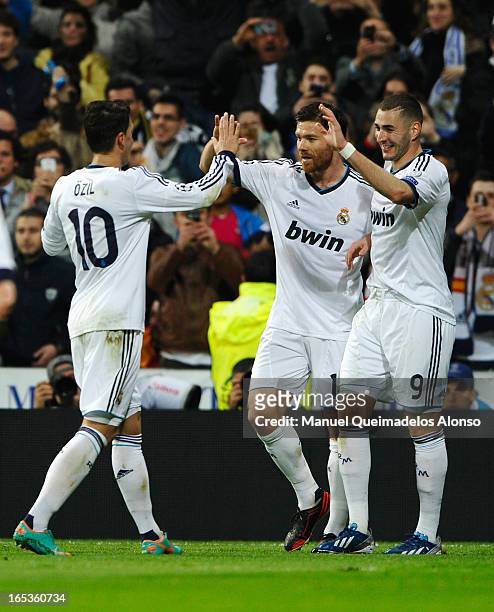 Karim Benzema of Real Madrid celebrates his goal with Xabi Alonso and Mesut Oezil during the UEFA Champions League Quarter Final first leg match...