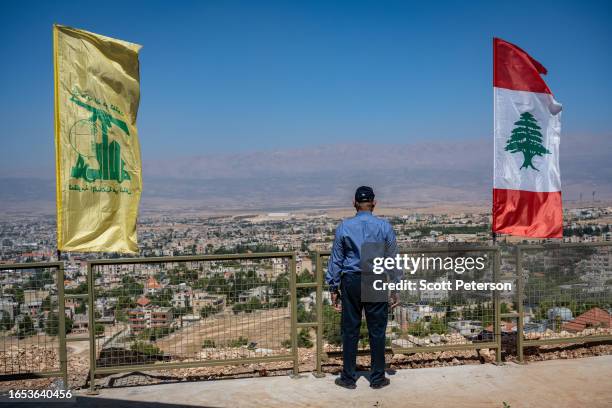 Man stands between Hezbollah and Lebanese flags, as Hezbollah, the Iran-backed Shiite militia of Lebanon, at the Baalbek Tourist Museum that just...