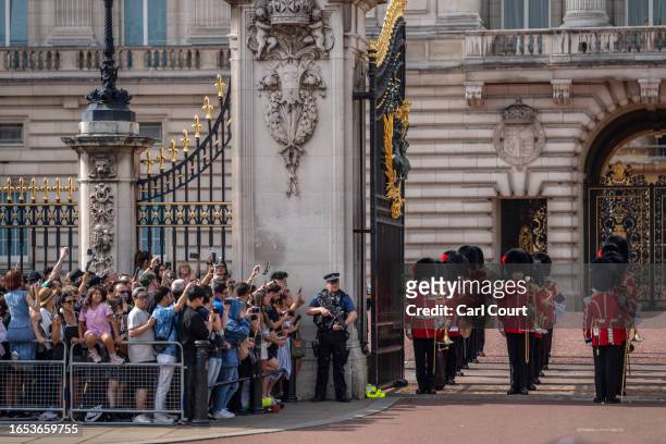 Tourists watch the Changing of the Guard outside Buckingham Palace on September 8, 2023 in London, England. Queen Elizabeth II passed away at her...