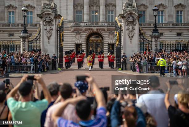 Tourists watch the Changing of the Guard outside Buckingham Palace on September 8, 2023 in London, England. Queen Elizabeth II passed away at her...