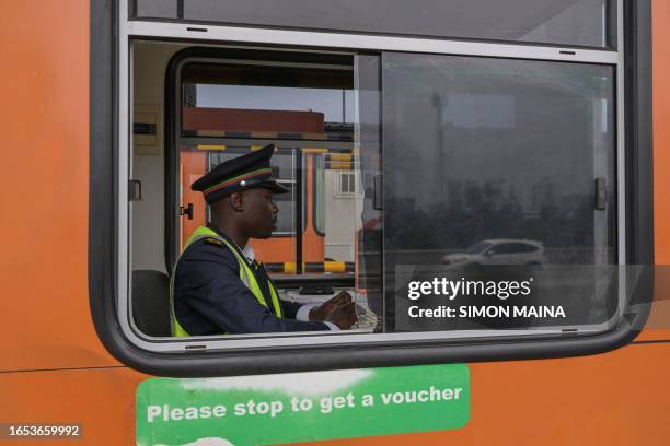 Toll attendant sits inside the paying booth of the expressway in Nairobi on September 8, 2023.