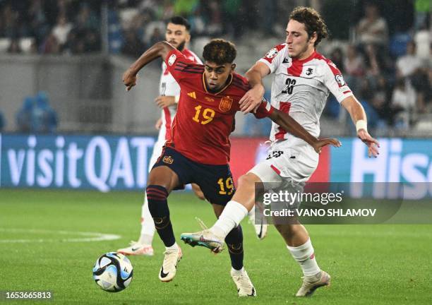 Spain's forward Lamine Yamal and Georgia's midfielder Luka Gagnidze fight for the ball during the UEFA Euro 2024 qualifying first round group A...