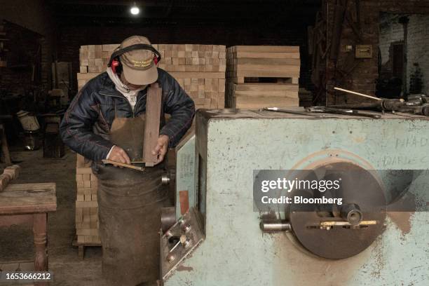 Worker inspects a piece of wood used in the production of furniture at a woodshop in Machagai, Chaco province, Argentina, on Wednesday, Sept. 6,...