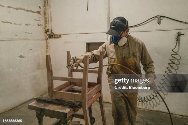 Worker applies a finish to a wood chair at a wood shop in Machagai, Chaco province, Argentina, on Wednesday, Sept. 6, 2023. The majority state-owned...
