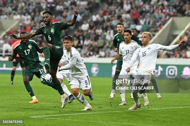 Saudi Arabia's midfileder Ali Hazazi runs with the ball past Costa Rica's defender Francisco Calvo and Costa Rica's forward Manfred Ugalde during the...