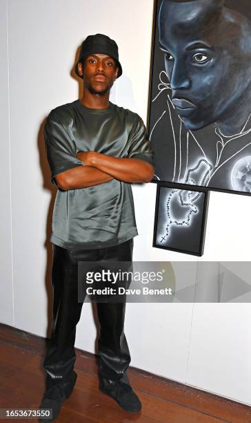 Micheal Ward poses in front of a portrait of himself at the opening night of Netflix's "Portrait Of A Top Boy" exhibition at Somerset House's...