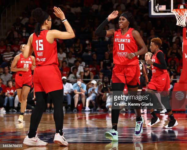 Allisha Gray high fives Rhyne Howard of the Atlanta Dream during the game against the Washington Mystics on September 8, 2023 at Entertainment &...
