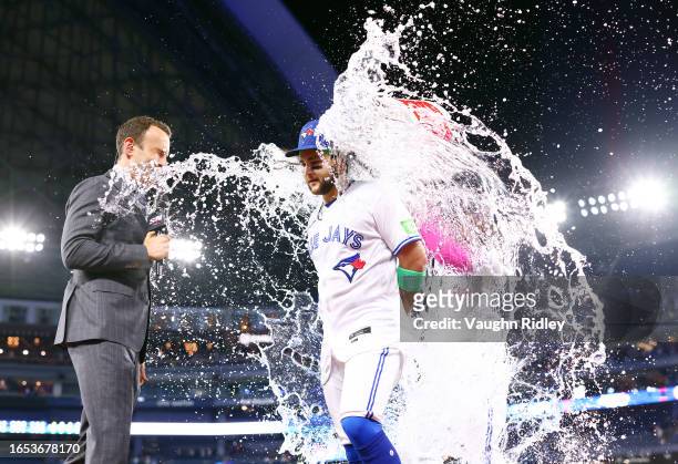 Bo Bichette of the Toronto Blue Jays is doused with water by Vladimir Guerrero Jr. #27 following a win against the Kansas City Royals at Rogers...