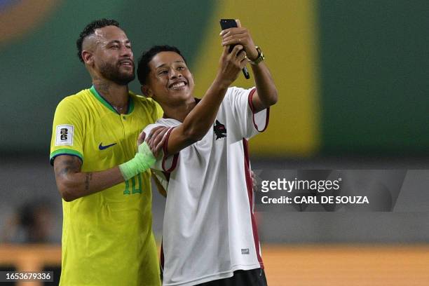 Brazil's forward Neymar poses for a selfie with a fan who ran into the pitch during the 2026 FIFA World Cup South American qualifiers football match...