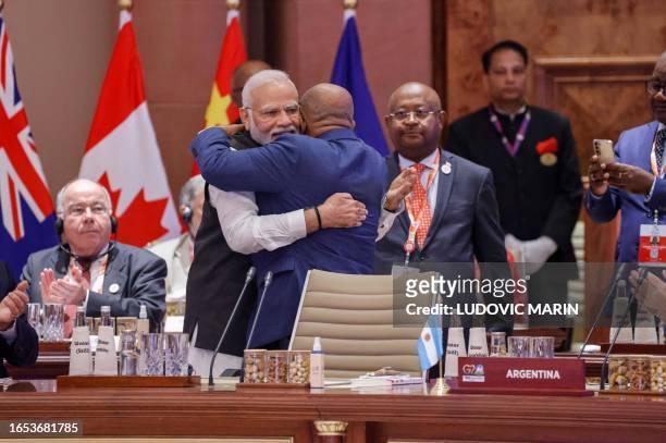 African Union Chairman and Comoros President Azali Assoumani and India's Prime Minister Narendra Modi hug each other during the first session of the...