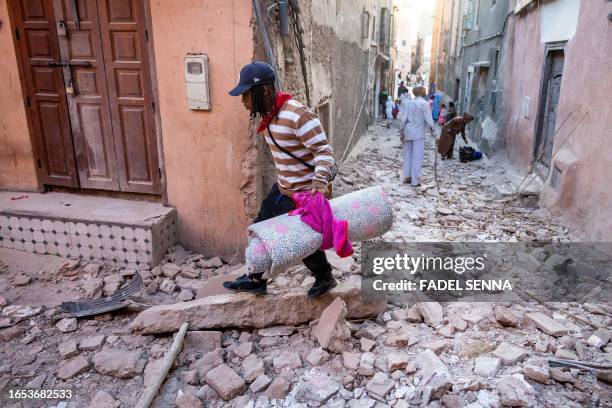 Man walks with his belongings through the rubble in an alleyway in the earthquake-damaged old city in Marrakesh on September 9, 2023. A powerful...