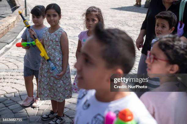 Young Iranian girl looks at a boy as she holds her water gun during the 2023 Water Gun Festival at Adrenaline Park in northwestern Tehran, September...