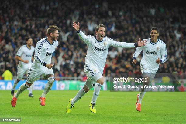 Gonzalo Higuain of Real Madrid celebrates his team's third goal with Sergio Ramos and Raphael Varane during the UEFA Champions League Quarter Final...