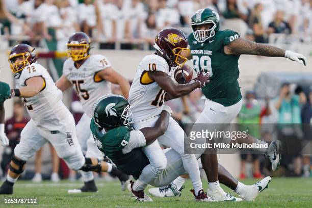 Stephen Bracey Jr. #10 of the Central Michigan Chippewas is tackled by Zion Young of the Michigan State Spartans in the second quarter of a game at...