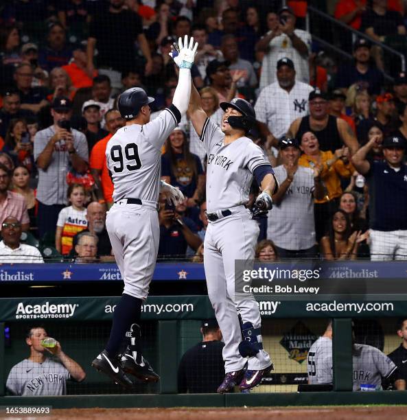 Aaron Judge of the New York Yankees high-fives Giancarlo Stanton after hitting a home run in the fifth inning against the Houston Astros at Minute...