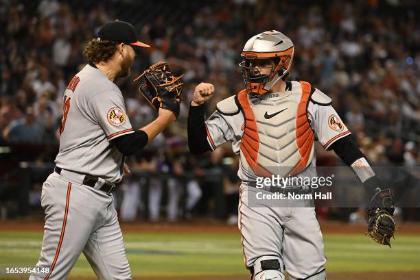 Adley Rutschman of the Baltimore Orioles celebrates with Cole Irvin after tagging out Corbin Carroll of the Arizona Diamondbacks at home plate during...