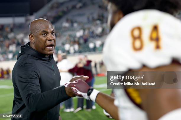Head coach Mel Tucker of the Michigan State Spartans bumps fists with Kenny Brewer III of the Central Michigan Chippewas after the Spartans defeated...