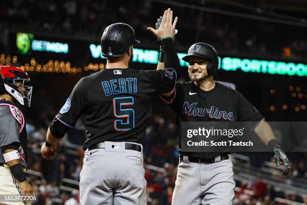 Garrett Hampson of the Miami Marlins celebrates with Jon Berti after hitting a two run home run against the Washington Nationals during the eleventh...