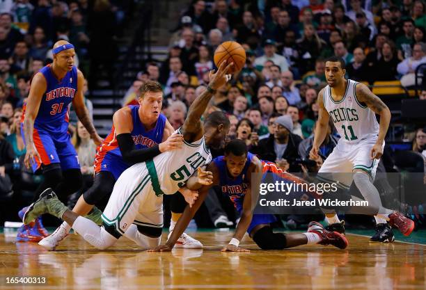 Terrence Williams of the Boston Celtics passes the ball from the floor over Jonas Jerebko and Khris Middleton of the Detroit Pistons during the game...