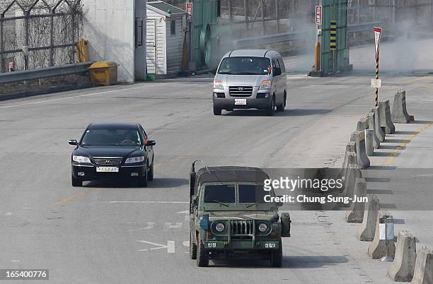 South Korean military vehicle leads cars from the Kaesong joint industrial complex in North Korea, at the inter-Korean transit office on April 4,...