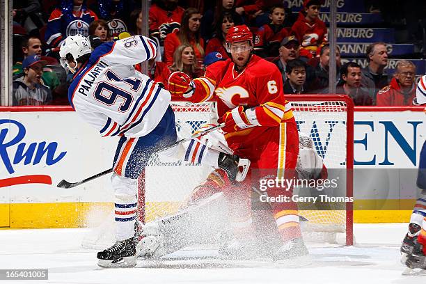 Cory Sarich of the Calgary Flames skates against Magnus Paajarvi of the Edmonton Oilers on April 3, 2013 at the Scotiabank Saddledome in Calgary,...