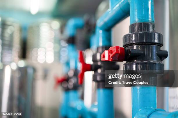 industrial interior of water pump. valves. pressure gauges. motors inside engine room. valve and pumps in an industrial room. urban modern powerful pipelines and pumps, automatic control systems - wasserrohr stock-fotos und bilder