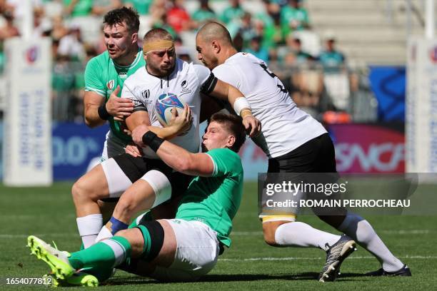 Romania's loosehead prop Iulian Hartig is tackled by Ireland's lock Joe McCarthy during the France 2023 Rugby World Cup Pool B match between Ireland...