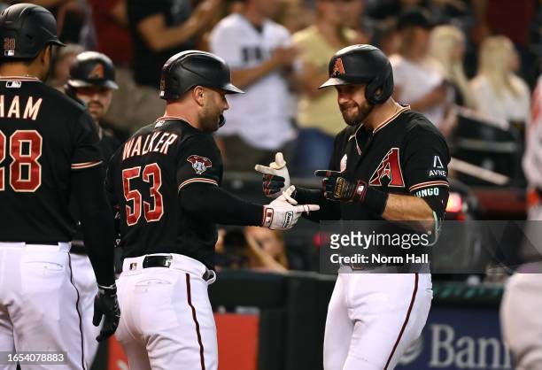 Christian Walker of the Arizona Diamondbacks celebrates with Evan Longoria after hitting a two-run home run against the Baltimore Orioles during the...