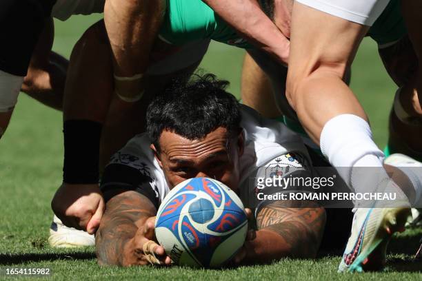 Romania's outside centre Jason Tomane makes the ball available during the France 2023 Rugby World Cup Pool B match between Ireland and Romania at...
