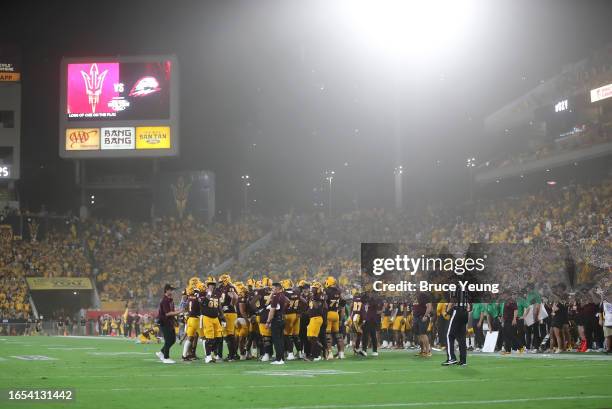 The Arizona State Sun Devils huddle up during a timeout amid a haboob dust strom during the second quarter against the Southern Utah Thunderbirds at...
