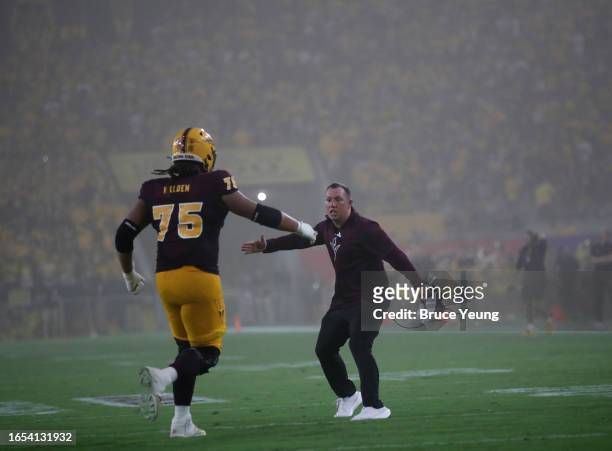Head Coach Kenny Dillingham of the Arizona State Sun Devils greets Bram Walden of the Arizona State Sun Devils after scoring the extra point during...