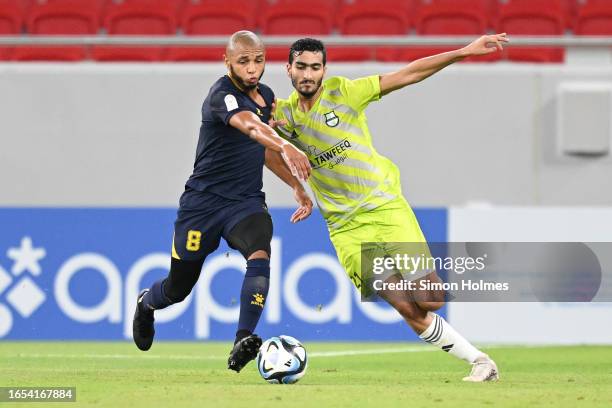 Mohammed Abdulla Al-Ishaq of Al Ahli and Yacine Brahimi of Al Gharafa battle for the ball during the Qatar Stars League match between Al Ahli and Al...