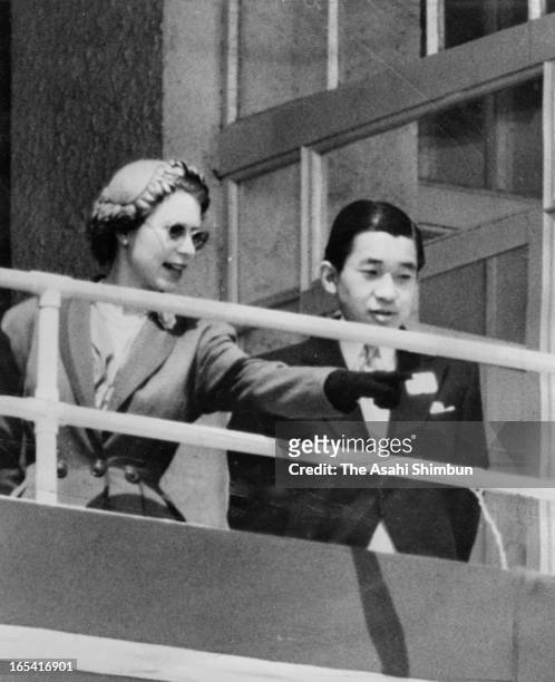 Queen Elizabeth II and Japan's Crown Prince Akihito are seen in the royal box at the Epsom Downs Racecourse on June 6, 1953 in Epsom, England. Crown...